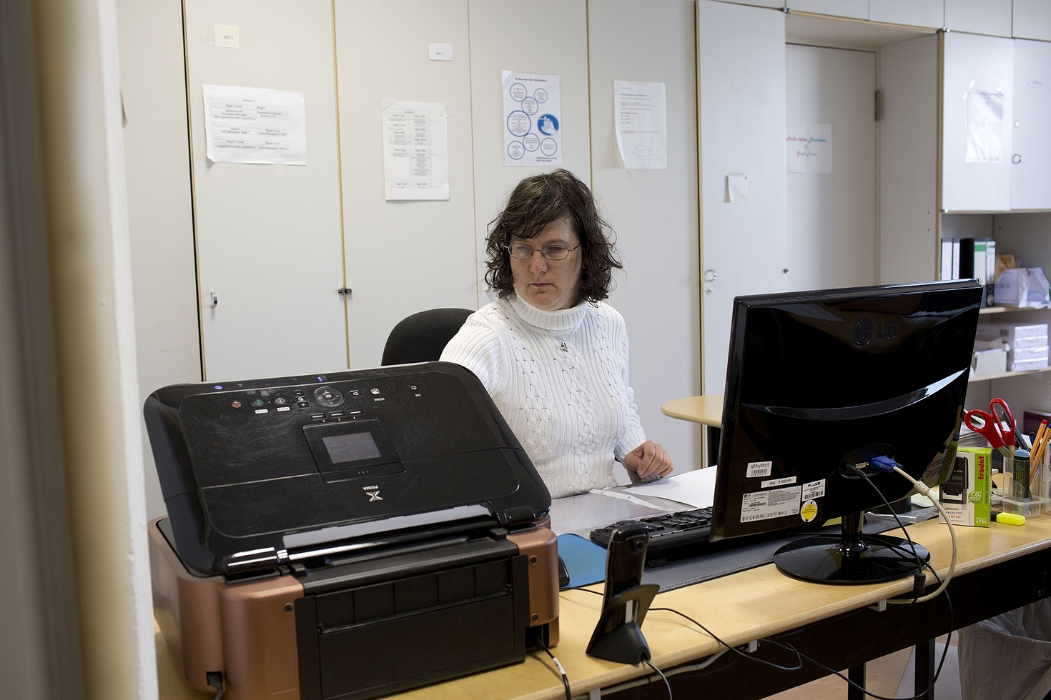 Foto: Frau arbeitet am Schreibtisch im Büro