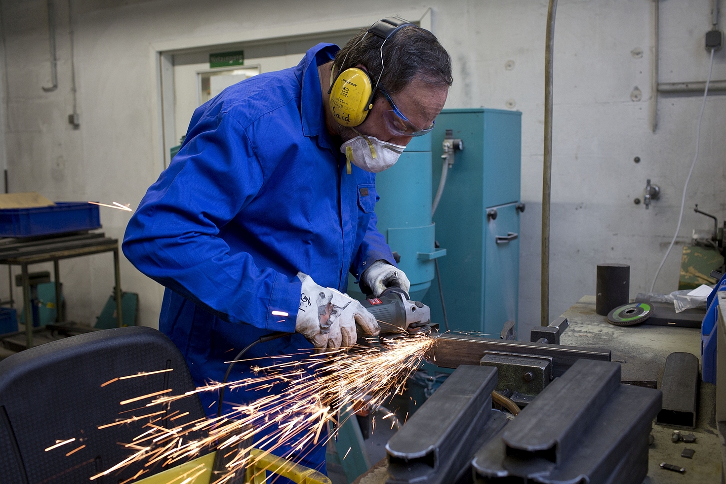 Foto: Mann arbeitet mit Säge an Metall