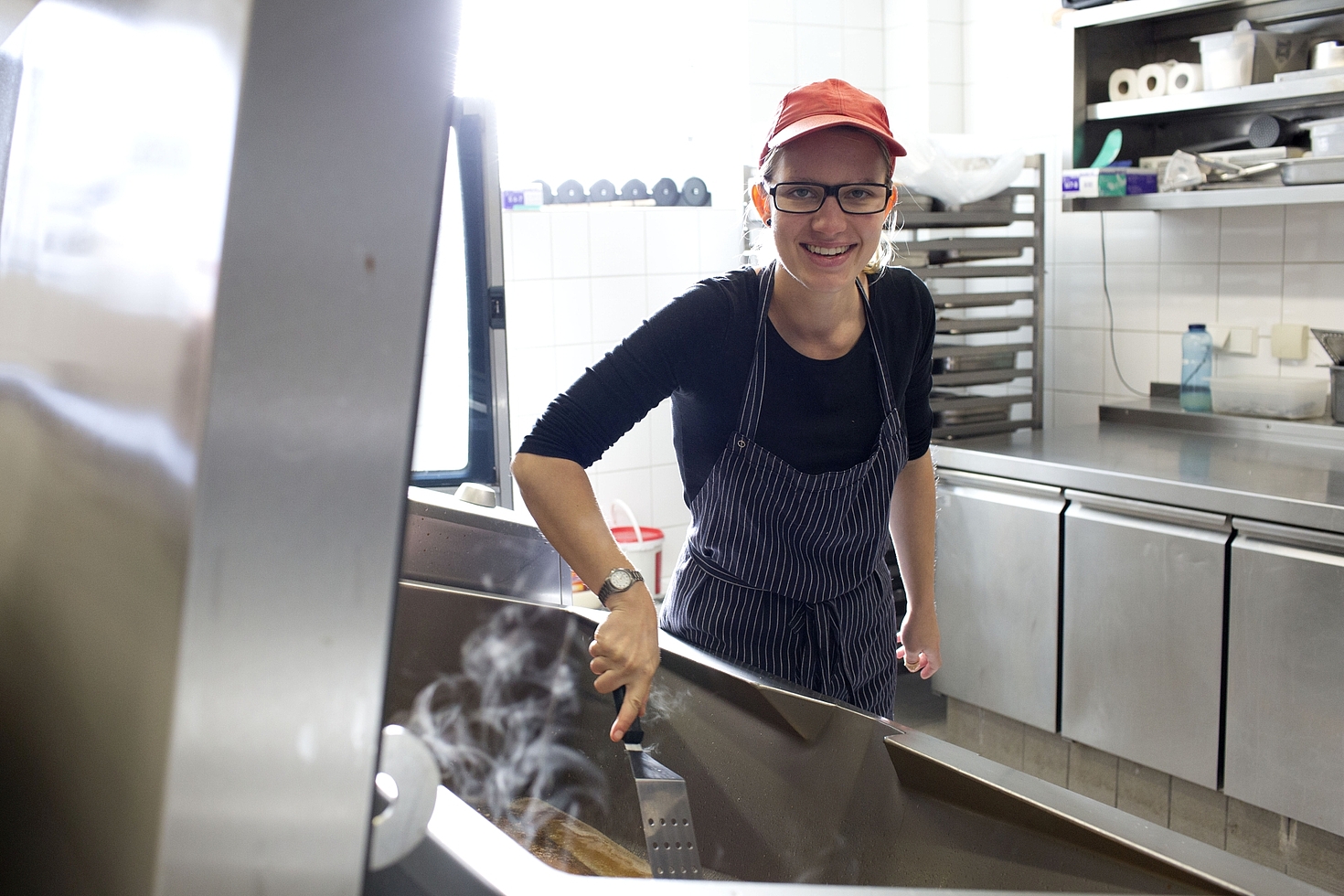 Foto: Frau, die in der Großküche arbeitet
