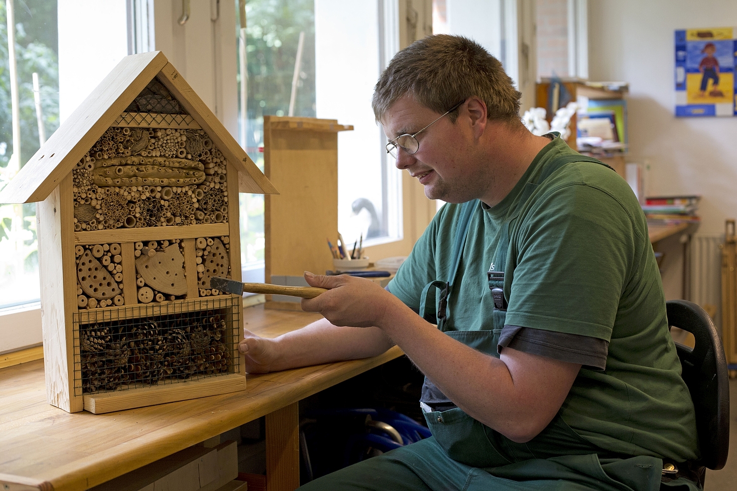 Foto: Mann arbeitet mit Hammer an Insektenhotel